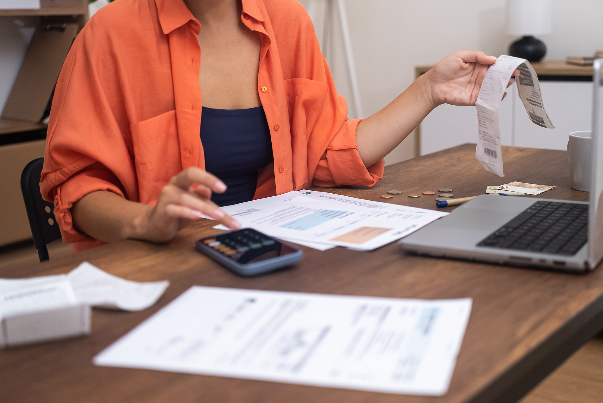 with laptop woman efficiently calculates household finances her smartphone